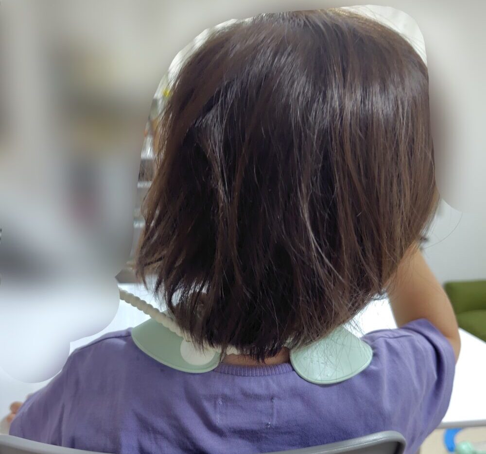 首後ろで留め具をとめている写真